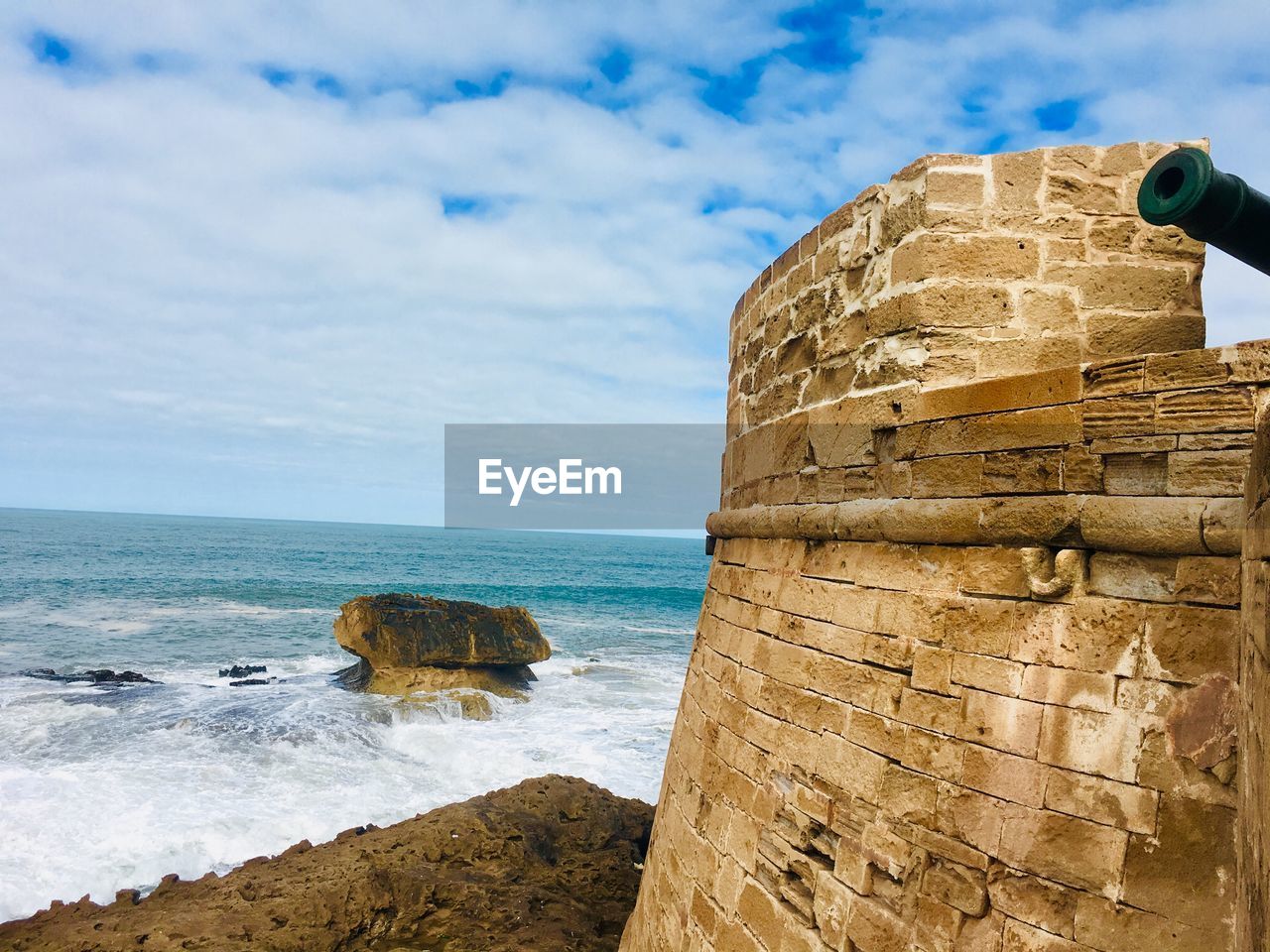 Rock formation on beach against sky