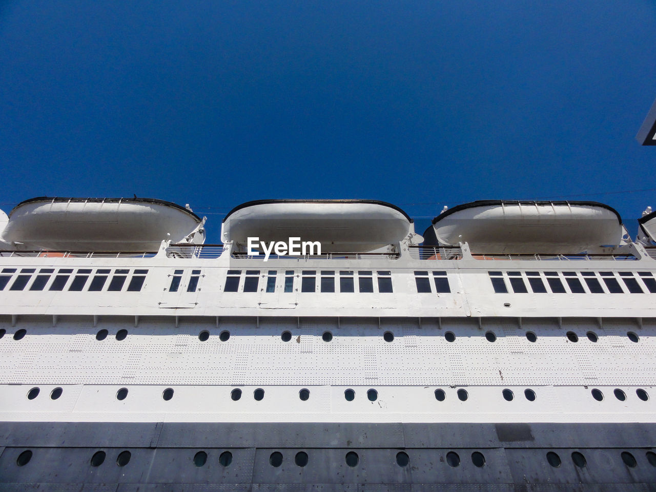 Low angle view of ship against clear blue sky