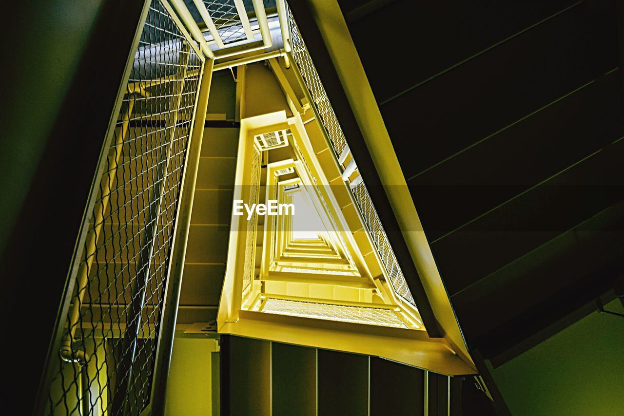 Directly below view of yellow metallic staircase in building