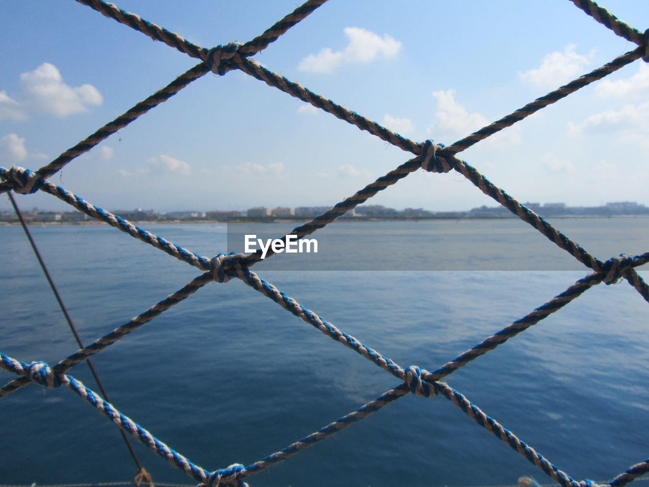 CLOSE-UP OF METAL CHAIN AGAINST SEA