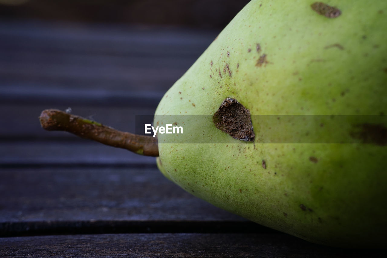 CLOSE-UP OF APPLE ON TABLE AGAINST WALL