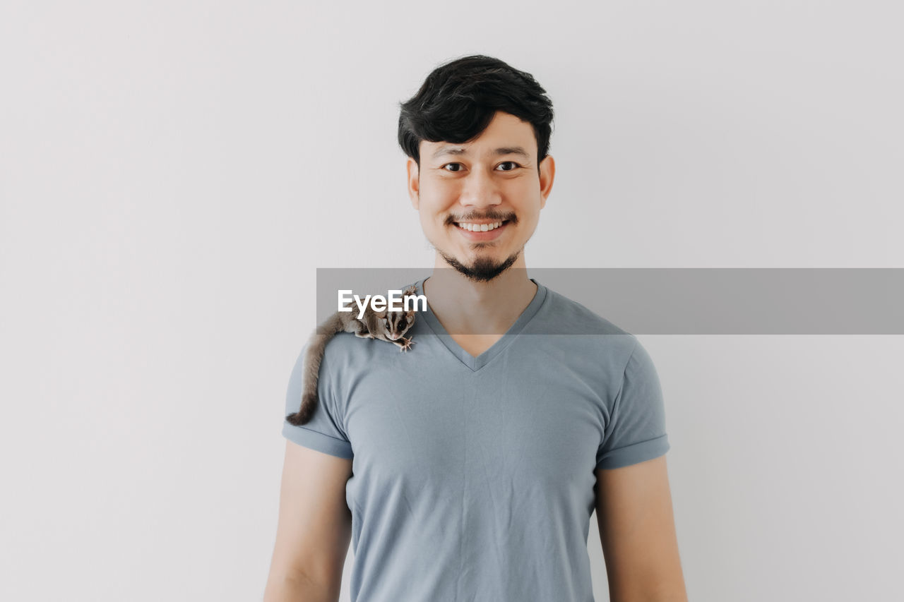 Portrait of smiling young man against white background