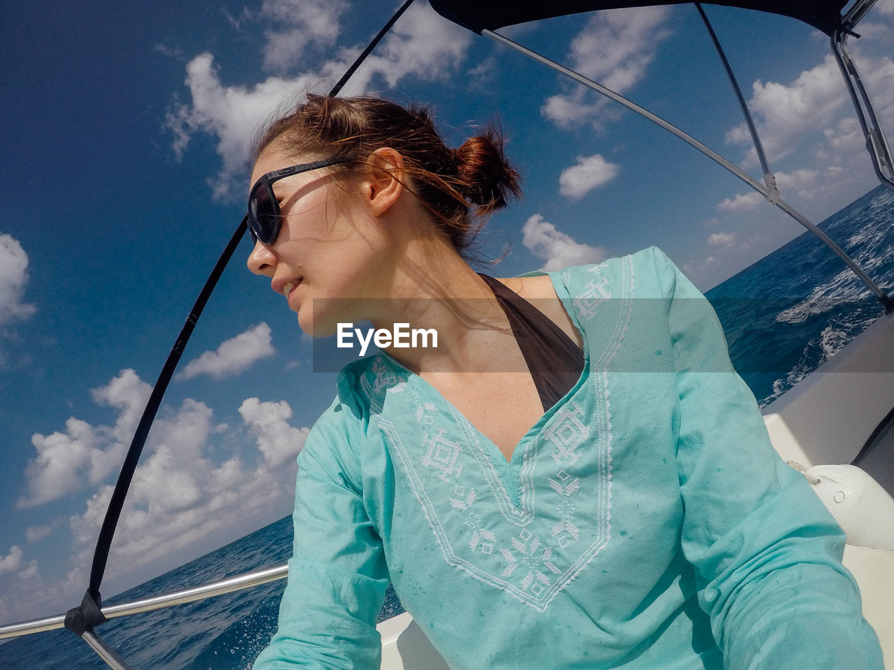 Young woman in boat against sky