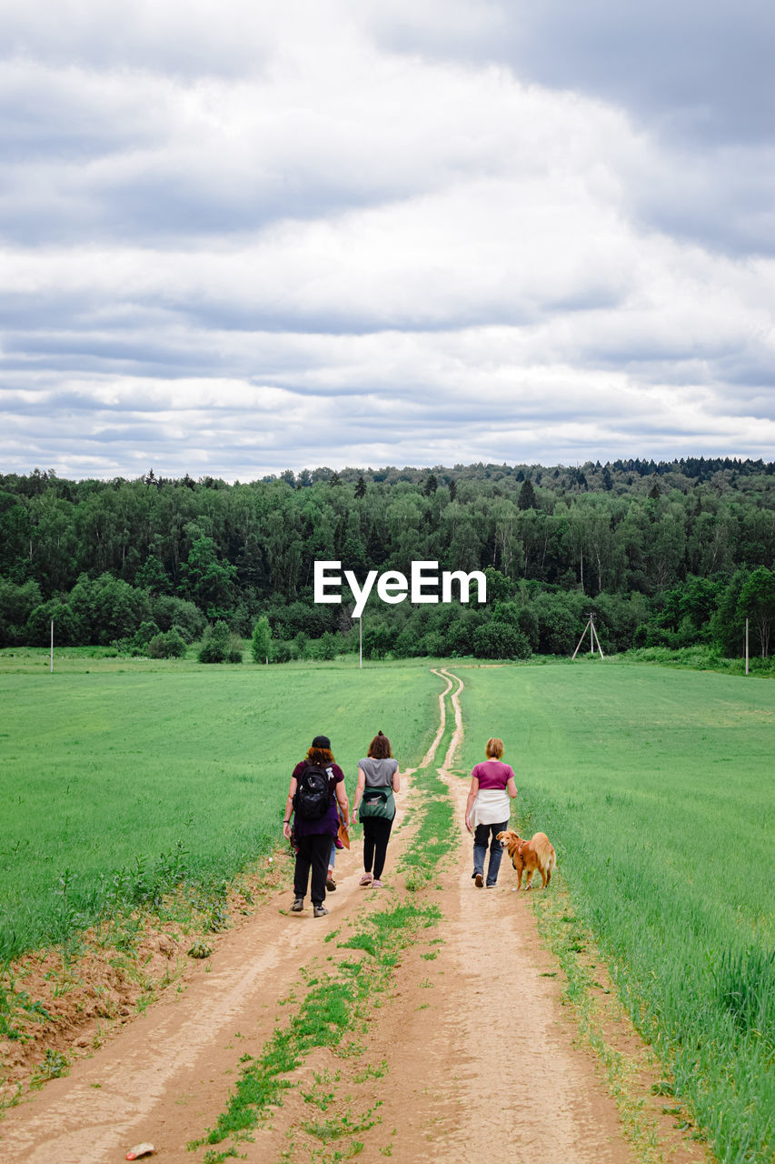 rural area, field, landscape, agriculture, sky, plant, cloud, environment, rural scene, farm, nature, grassland, land, group of people, adult, men, hill, meadow, grass, road, walking, rear view, dirt, transportation, women, tree, pasture, green, day, animal, dirt road, animal themes, crop, growth, outdoors, mammal, full length, beauty in nature, occupation, footpath, scenics - nature, soil, prairie, plain, lifestyles, domestic animals, person, medium group of people, the way forward, group