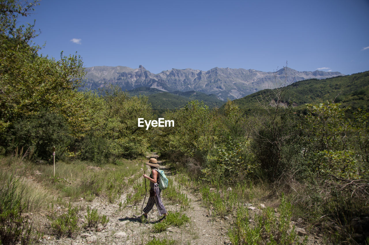 Woman standing on mountain against sky