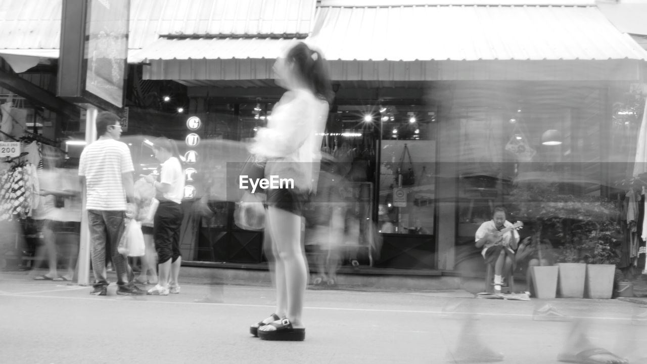 BLURRED MOTION OF WOMAN WALKING IN CITY