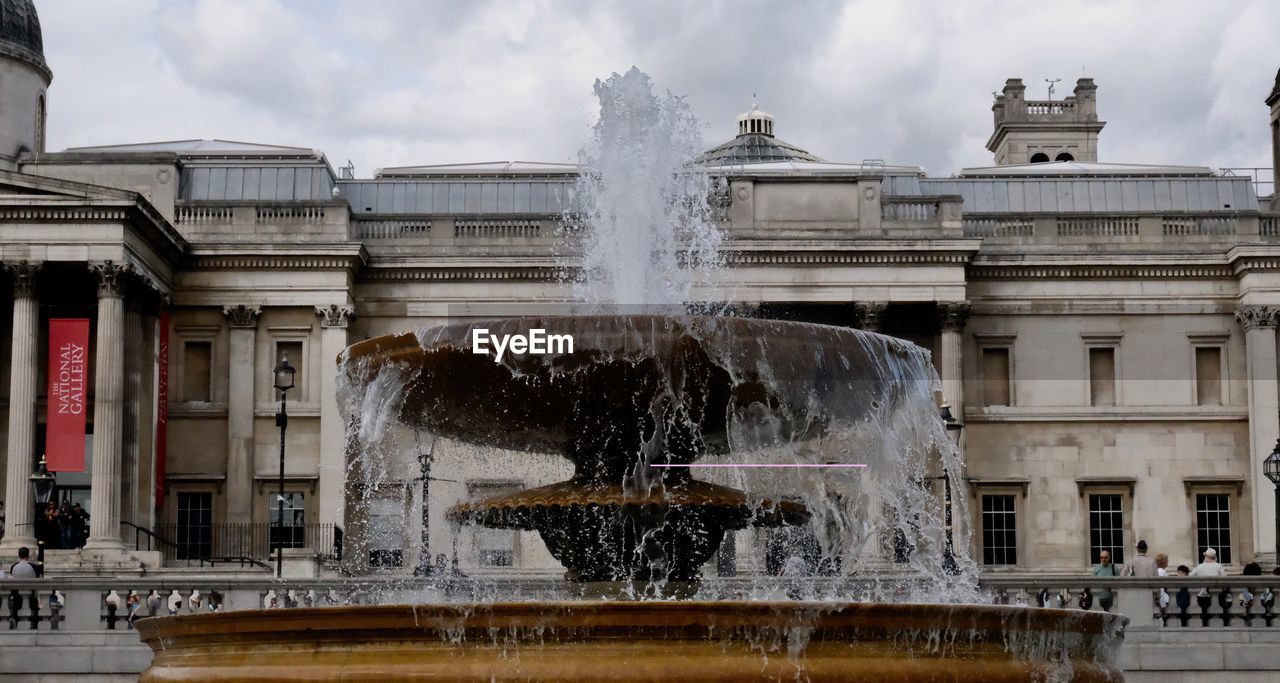 FOUNTAIN IN CITY AGAINST SKY