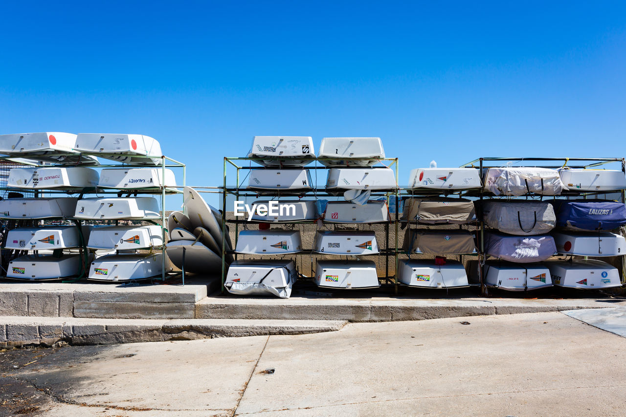 Boats arranged on metal against clear sky