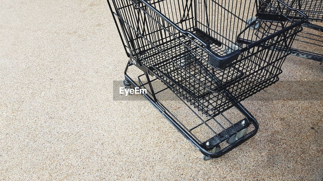 Black shopping trolley on stone floor