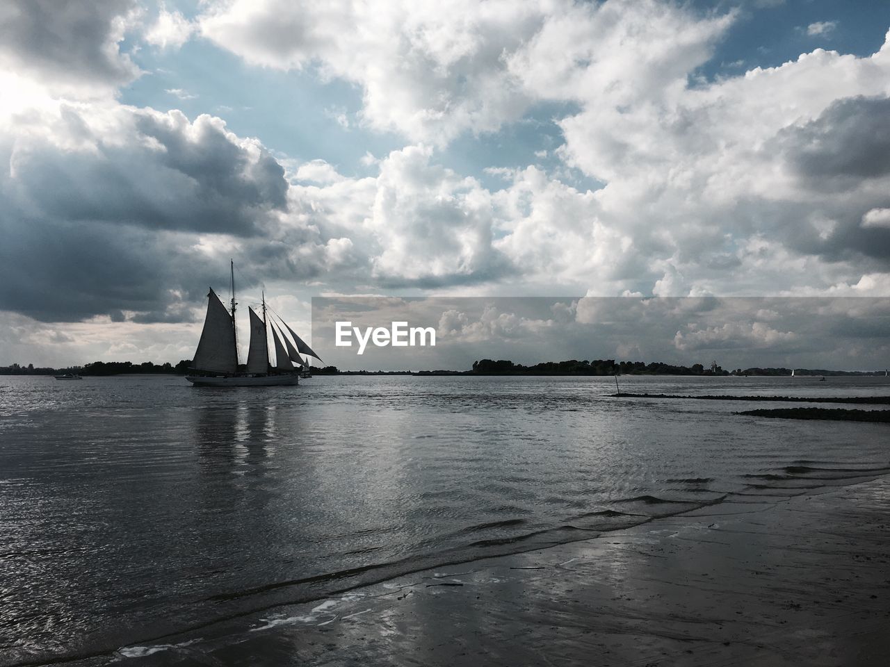 VIEW OF SAILBOAT IN SEA AGAINST CLOUDY SKY