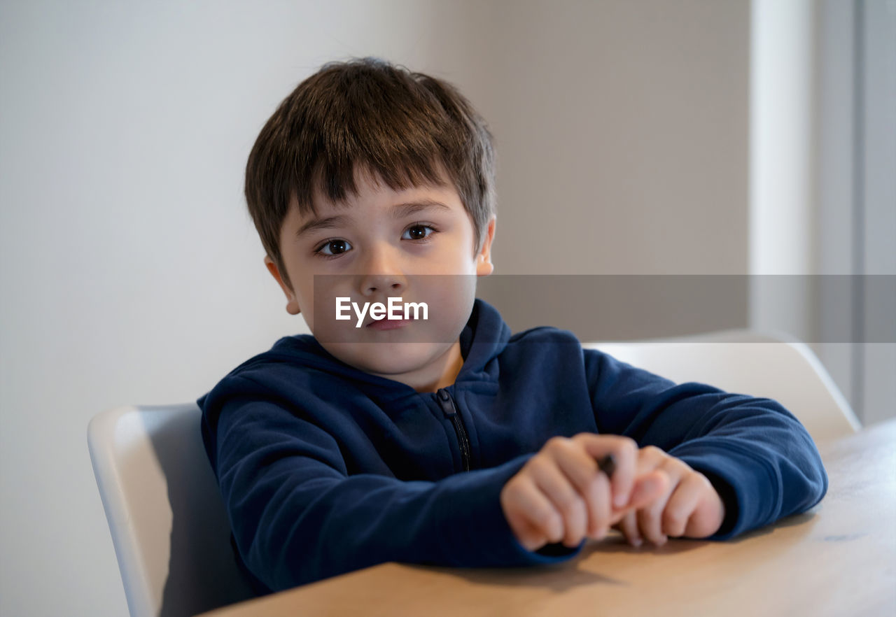 Portrait of boy sitting at home