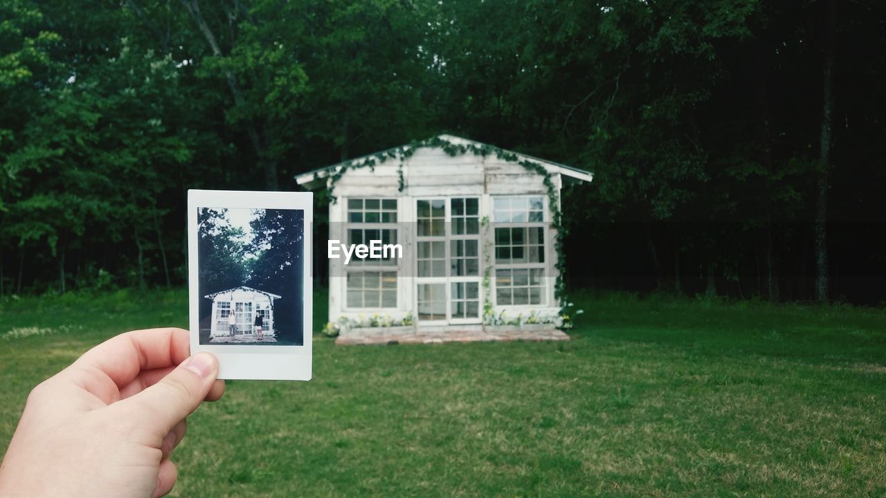 Cropped hand showing house photograph