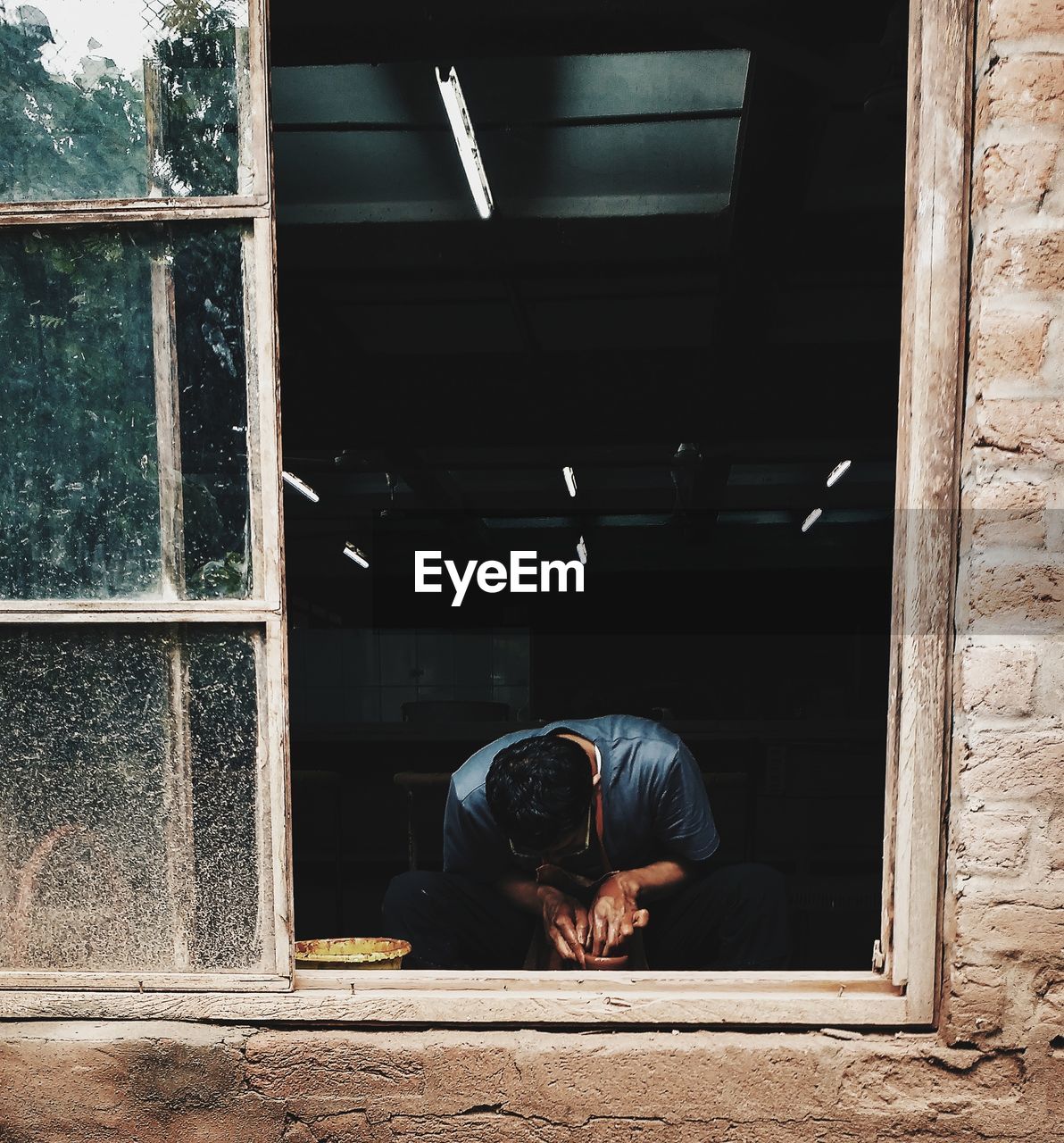 Young man seen through window