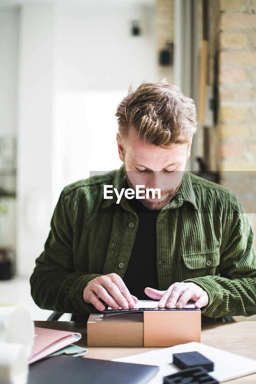 Male entrepreneur working with boxes at home office