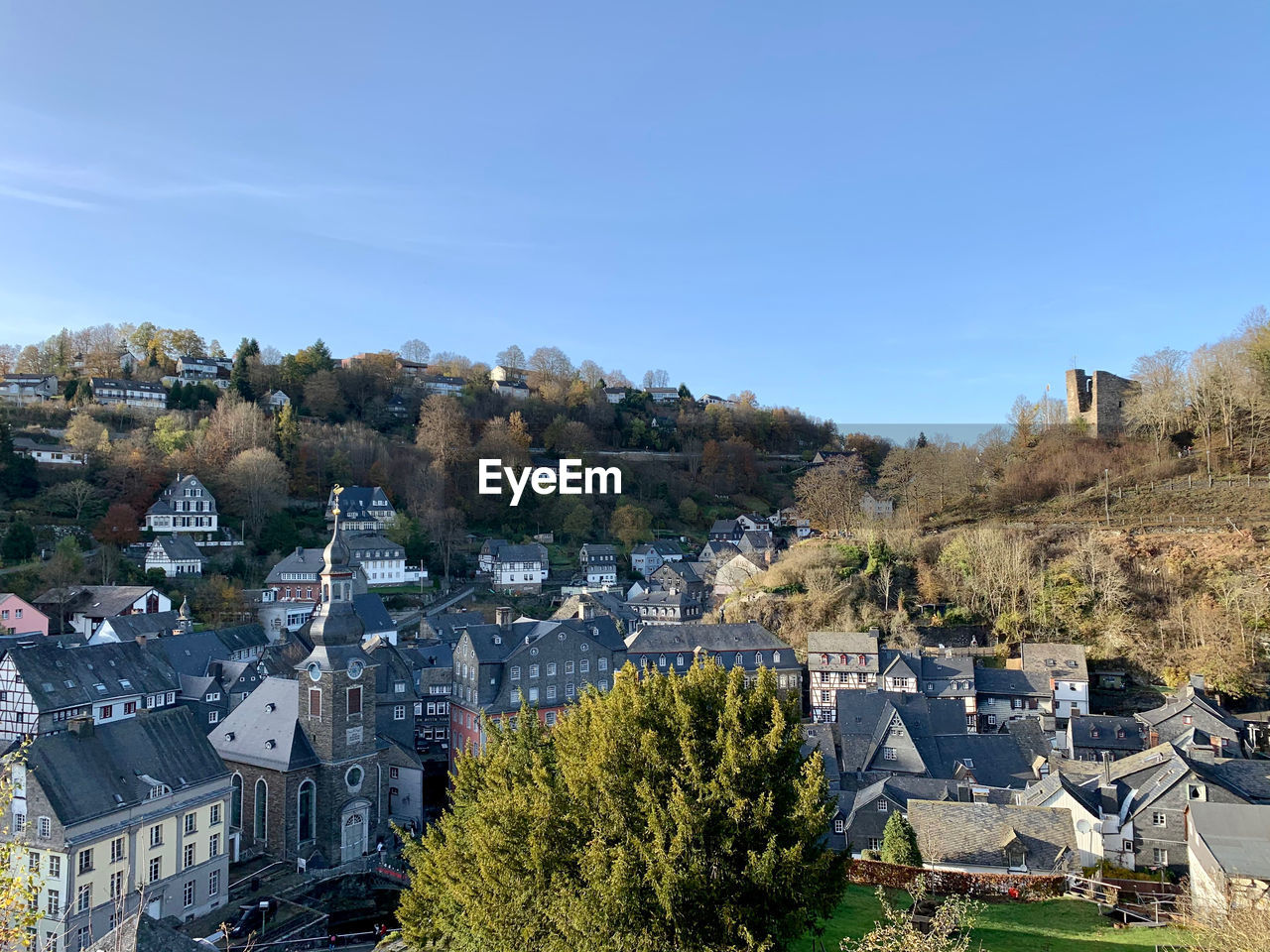 HIGH ANGLE VIEW OF TOWNSCAPE AND TREES AGAINST CLEAR SKY