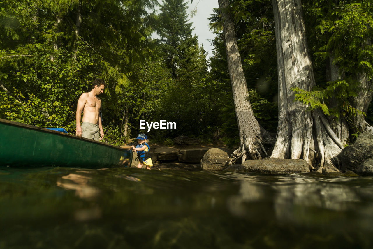 A young girl walks next to a canoe on lost lake in oregon.