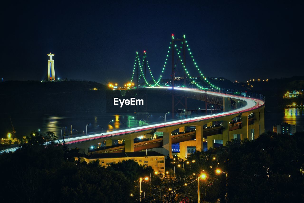 ILLUMINATED BRIDGE IN CITY AT NIGHT