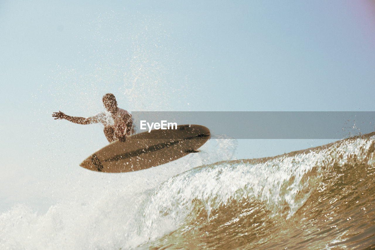 Man surfing in sea against sky