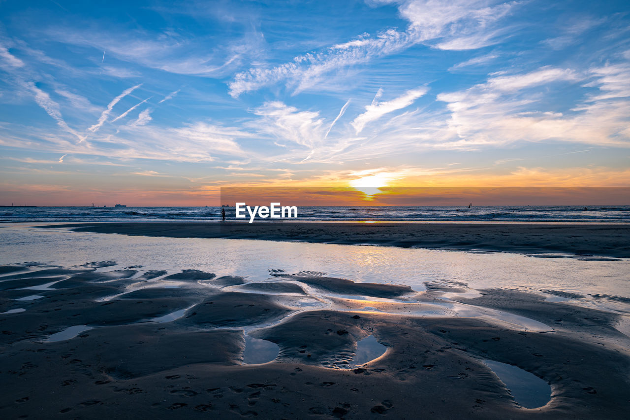 Sunset in the north sea with natural water-sand pattern in the foreground