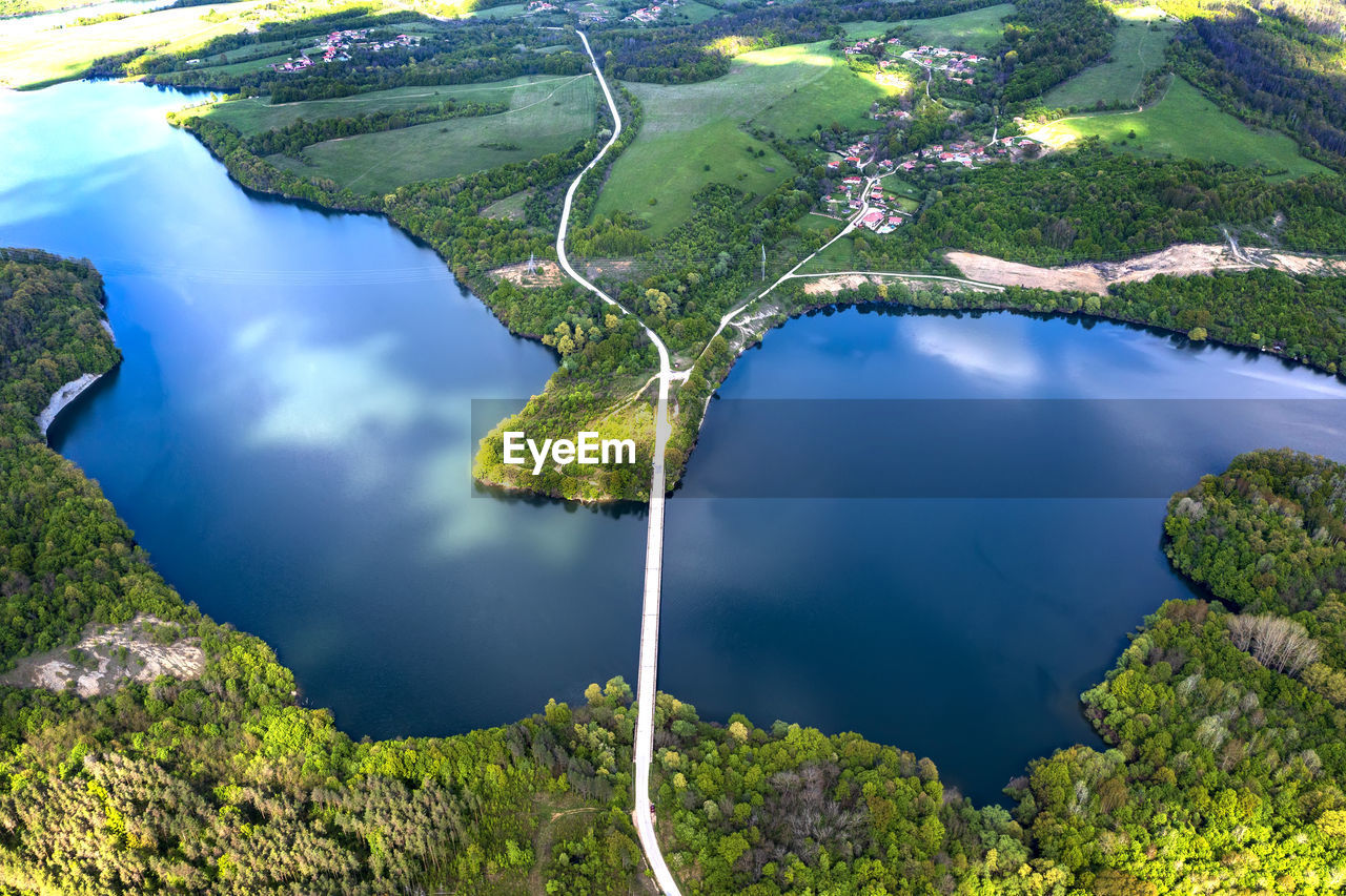 Aerial view from a drone to a lake and a road between hills.