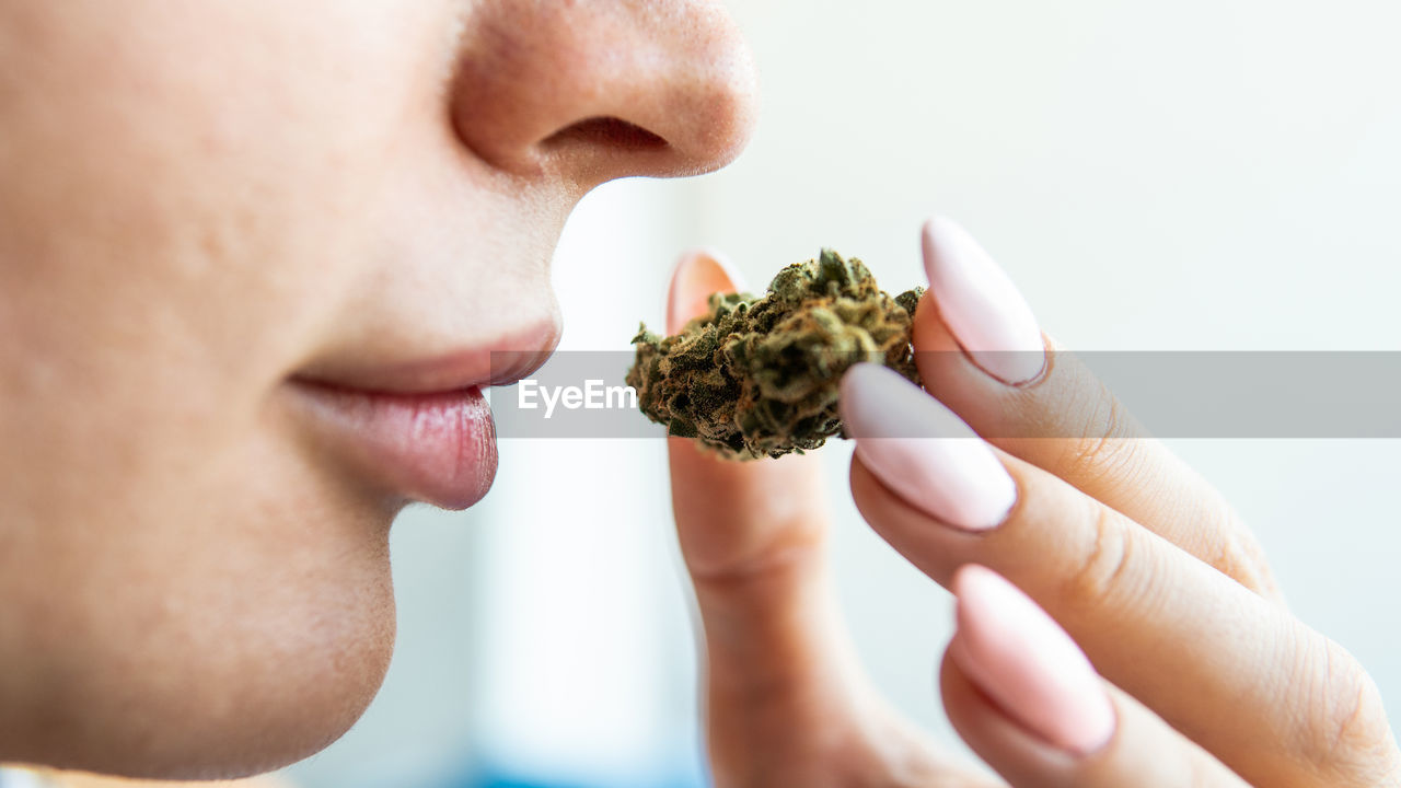 CLOSE-UP OF WOMAN HOLDING CIGARETTE