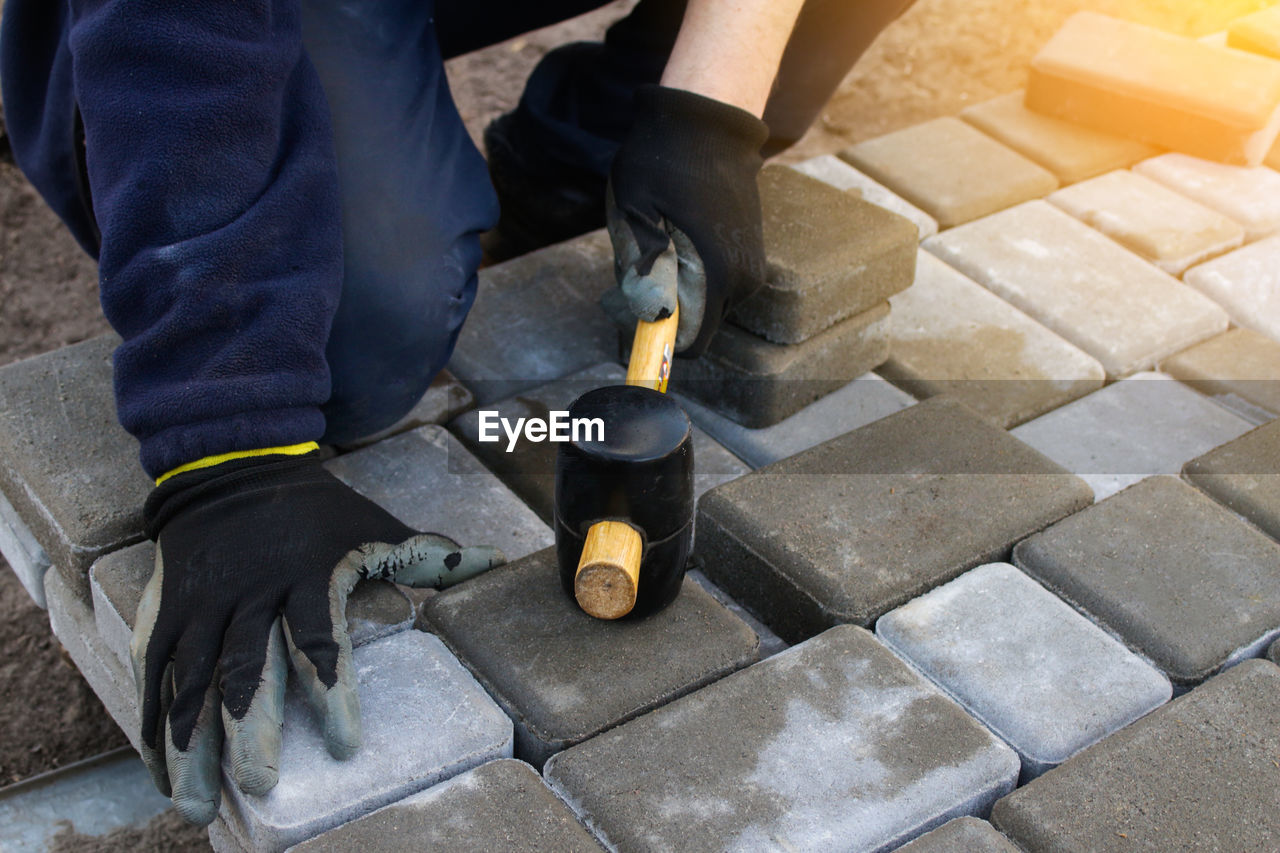 Paver master. man lays paving stones in layers. garden brick pathway paving by professional paver 