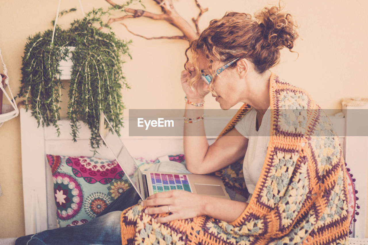 Side view of woman using laptop