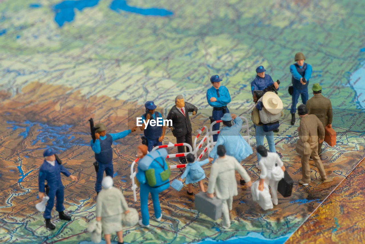 High angle view of figurines standing on map