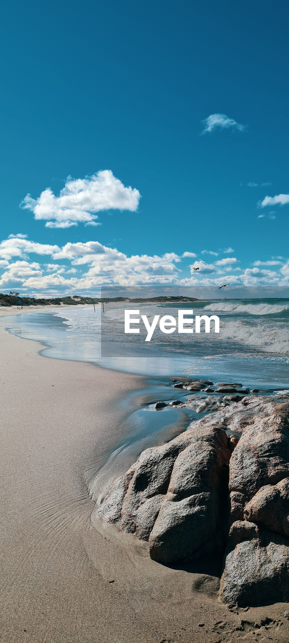 Scenic view of beach against blue sky