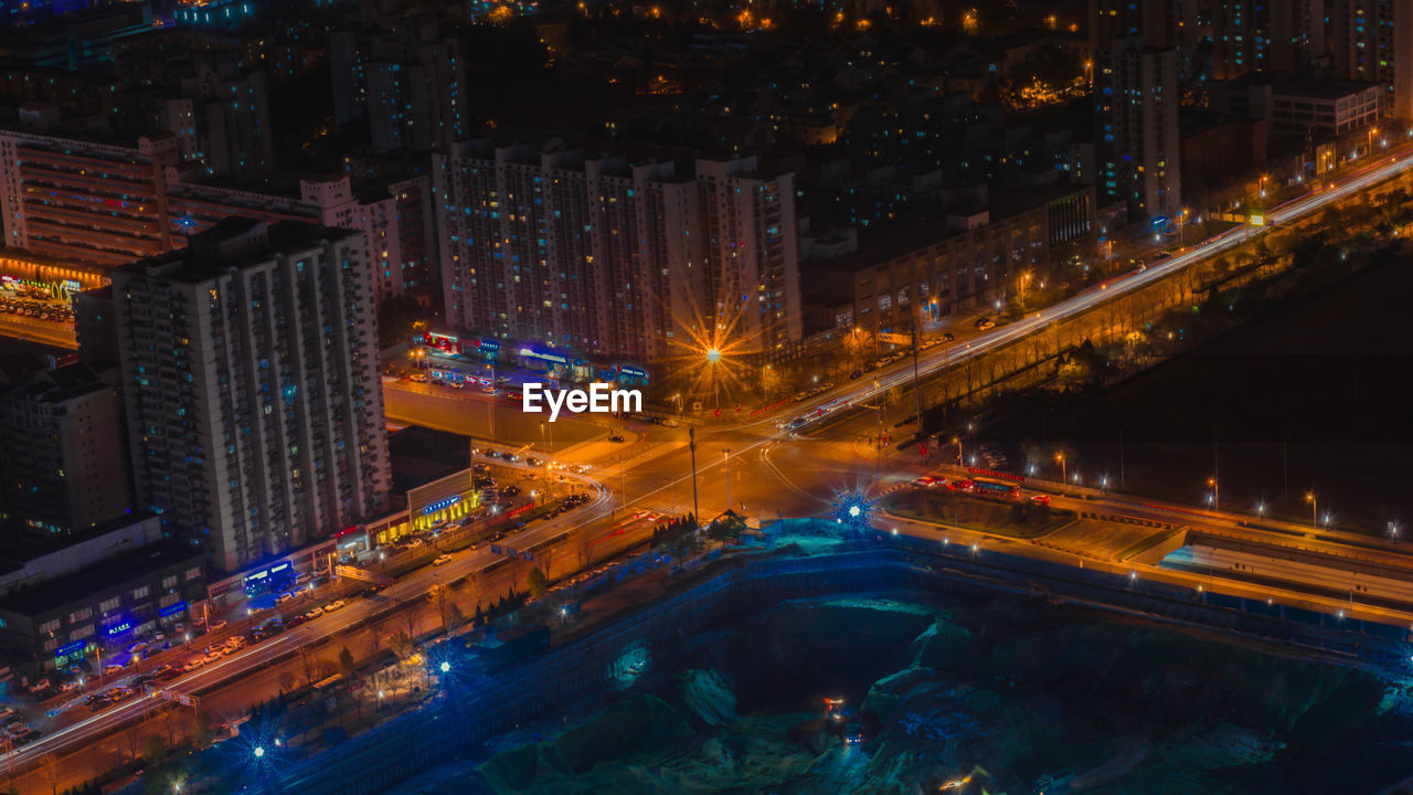 High angle view of illuminated city street and buildings at night