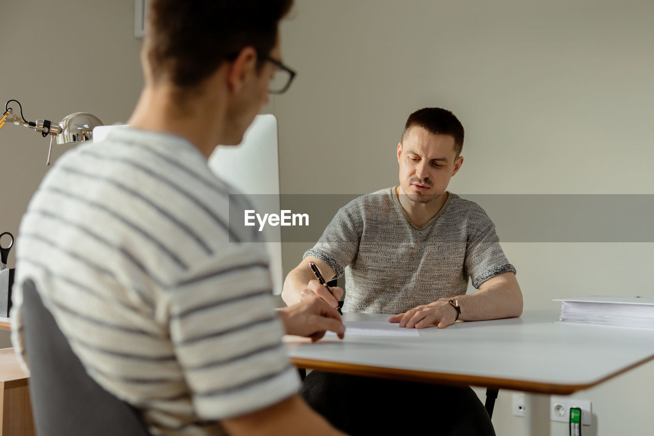 Serious professional man consulting client in office. two mens having meeting