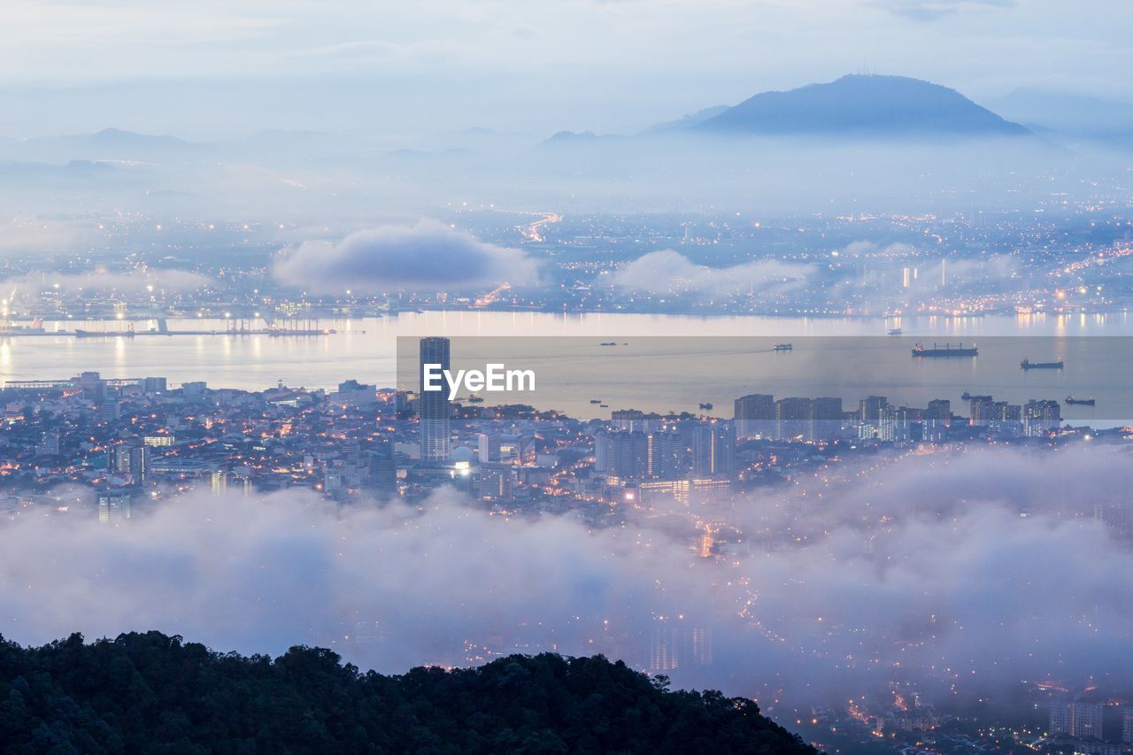 Panoramic view of city against cloudy sky