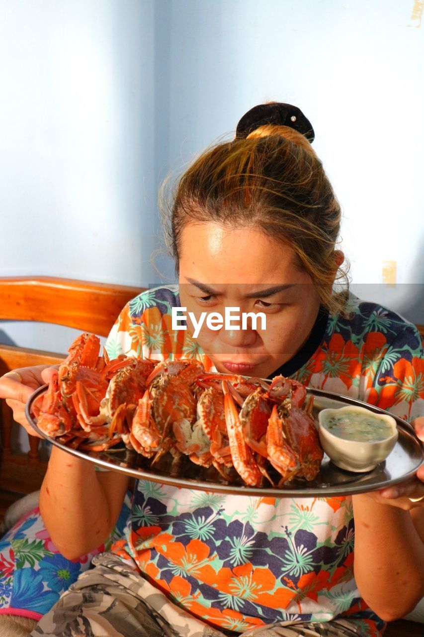 Woman holding crabs on bed at home