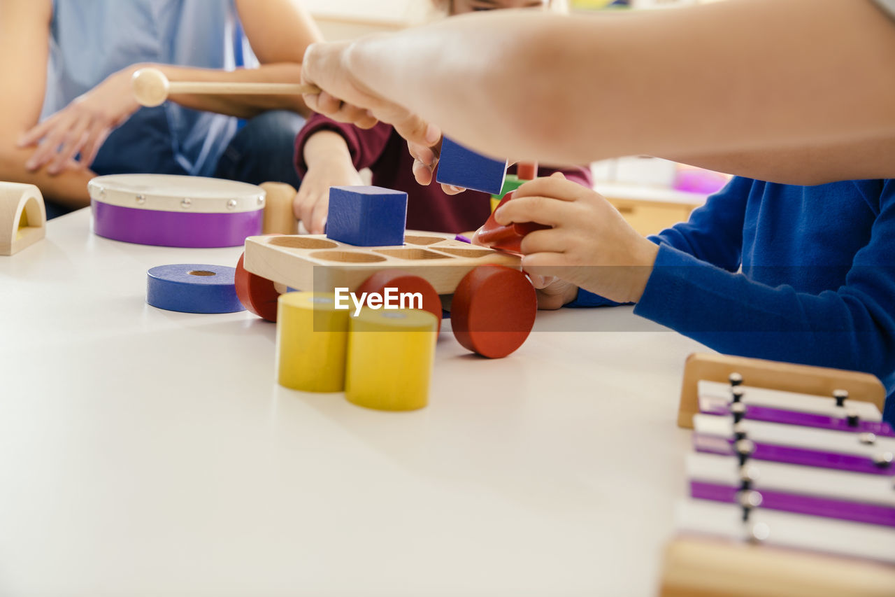 Close-up of children playing with musical instruments and toys in kindergarten