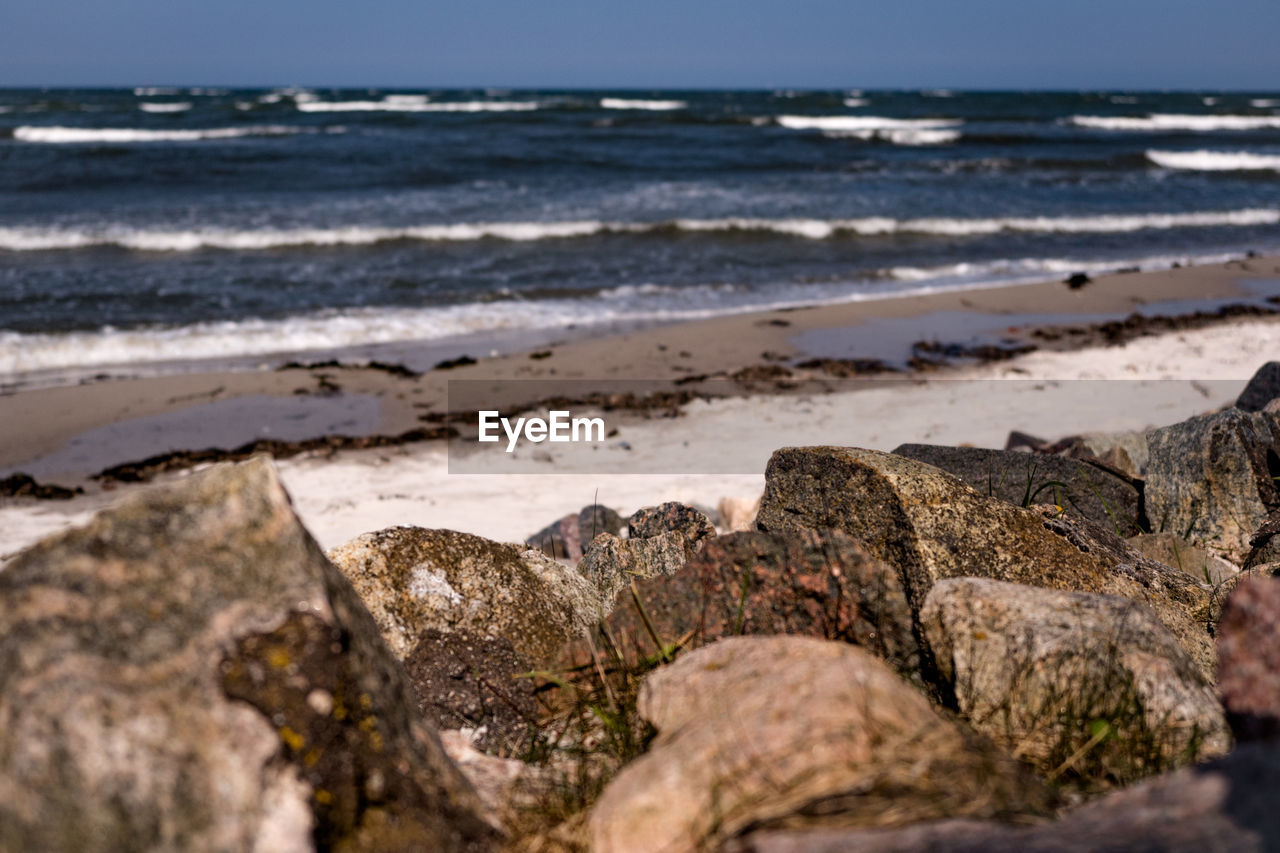 Close-up of rocks on beach against sky