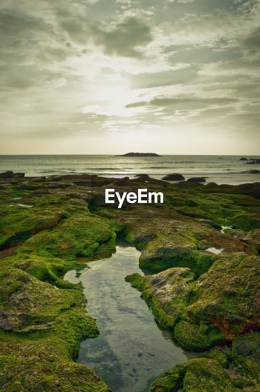 Scenic view of calm sea against cloudy sky