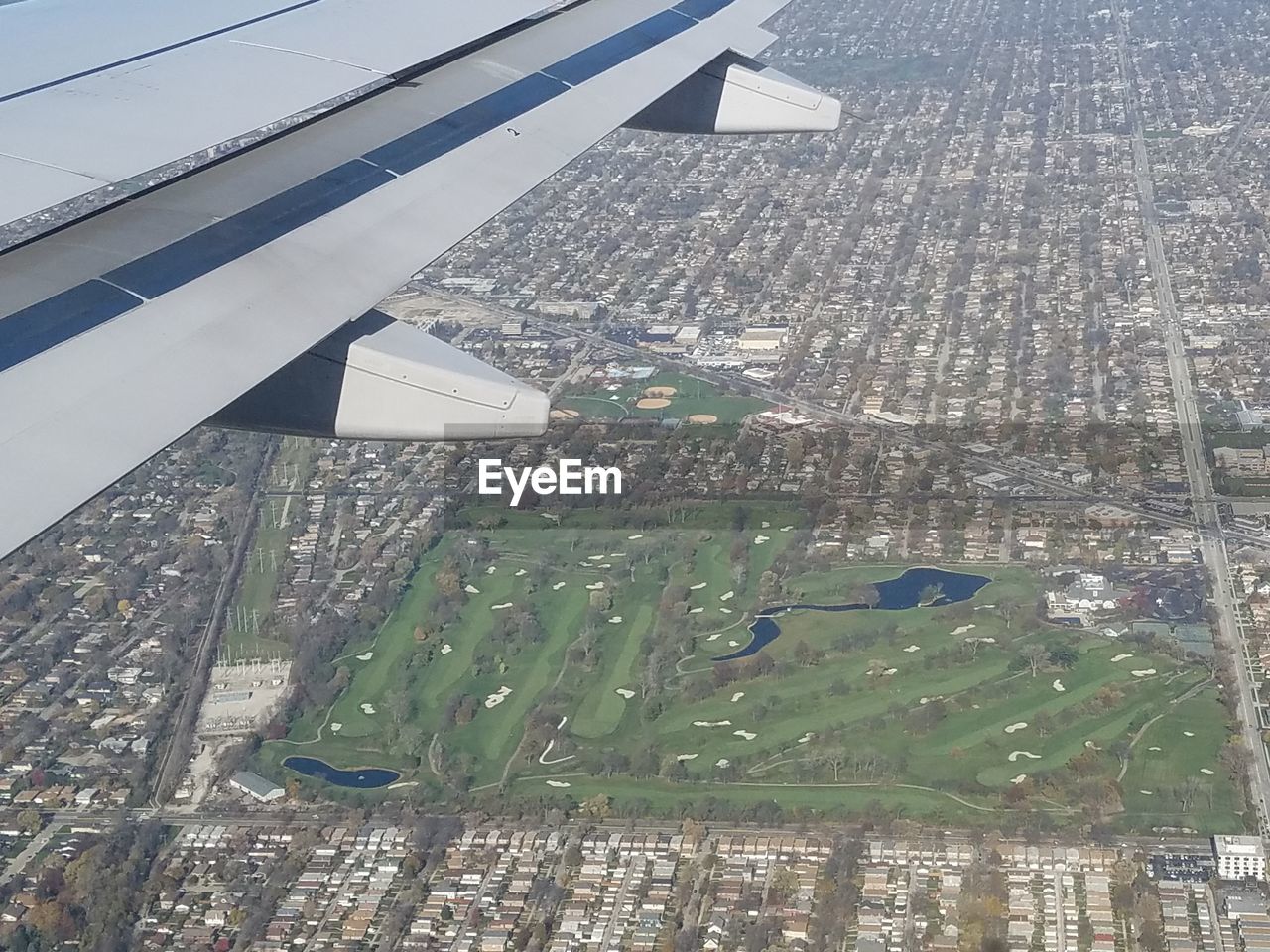 HIGH ANGLE VIEW OF CITYSCAPE SEEN THROUGH AIRPLANE