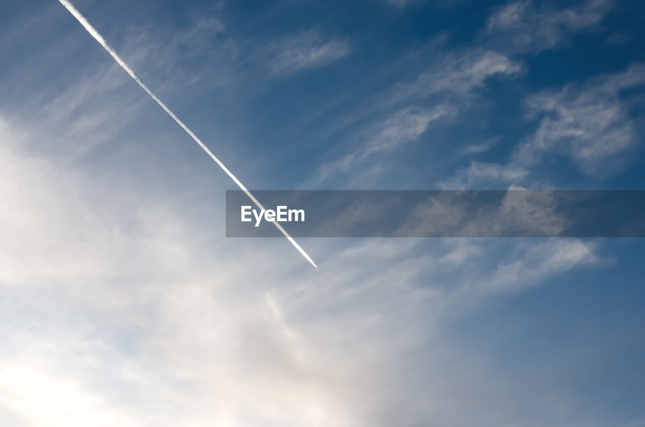 LOW ANGLE VIEW OF VAPOR TRAILS AGAINST BLUE SKY