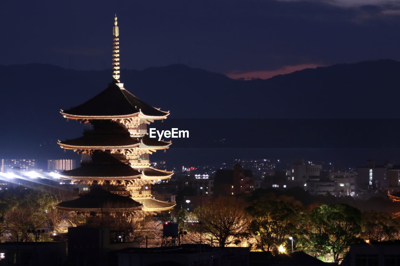 Illuminated pagoda in city at night