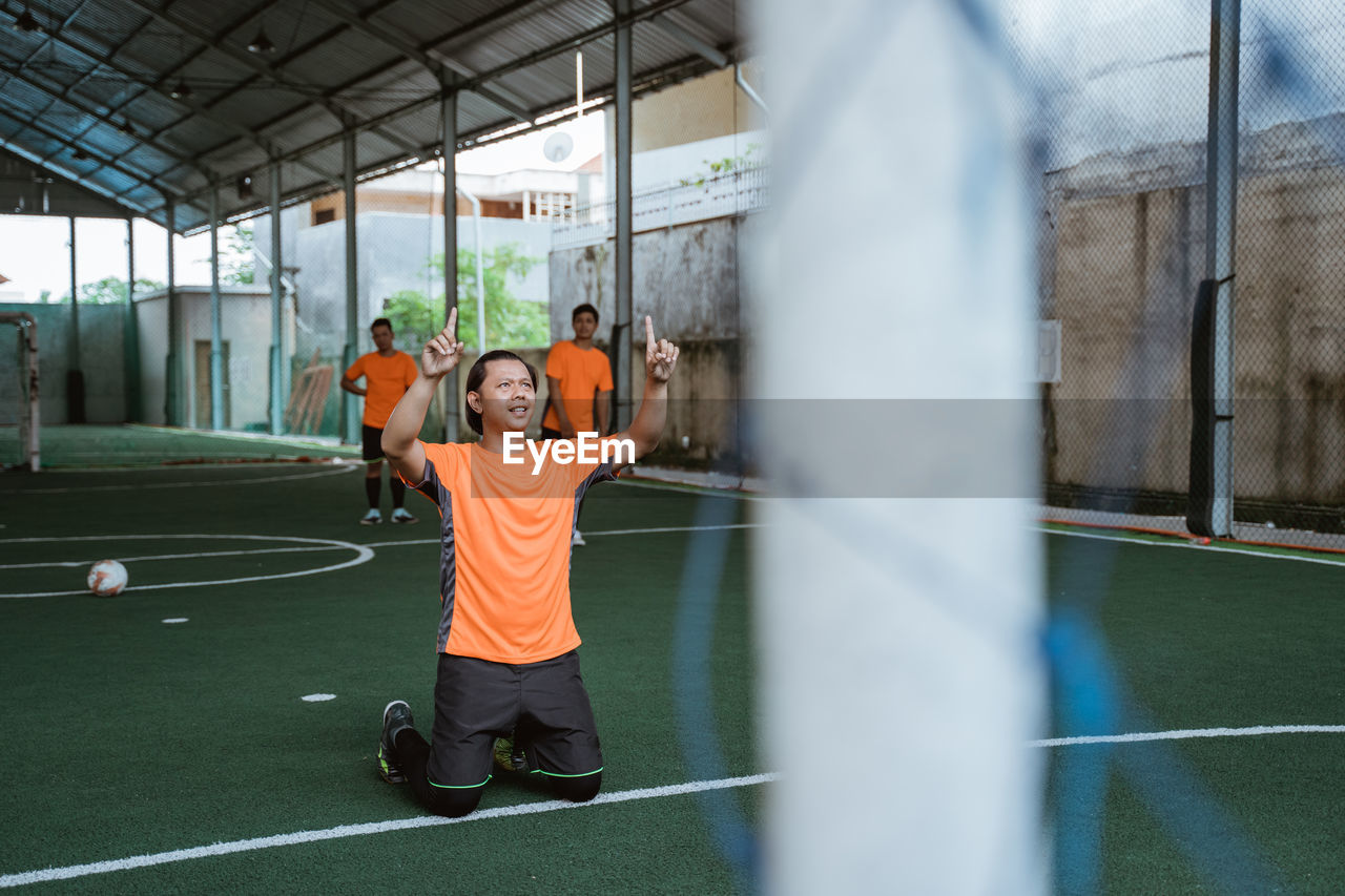 rear view of man standing on soccer field