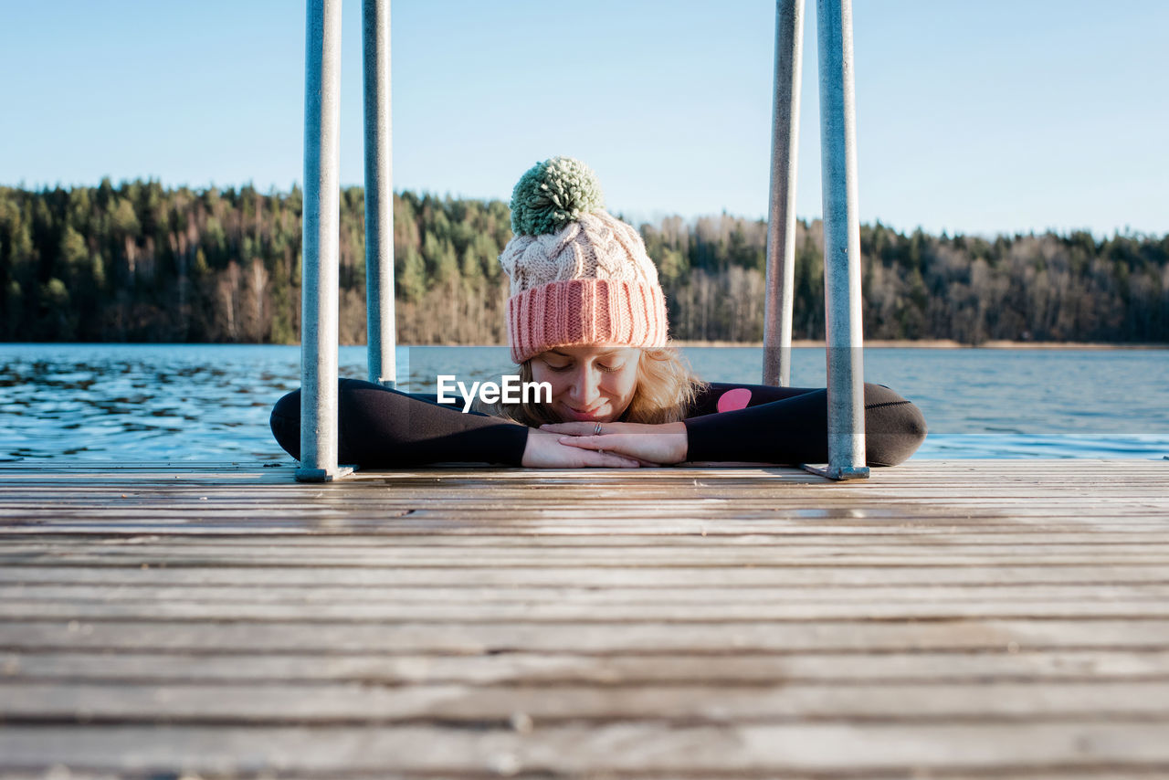 Woman cold water ice swimming in the sea in sweden leaning on a pier