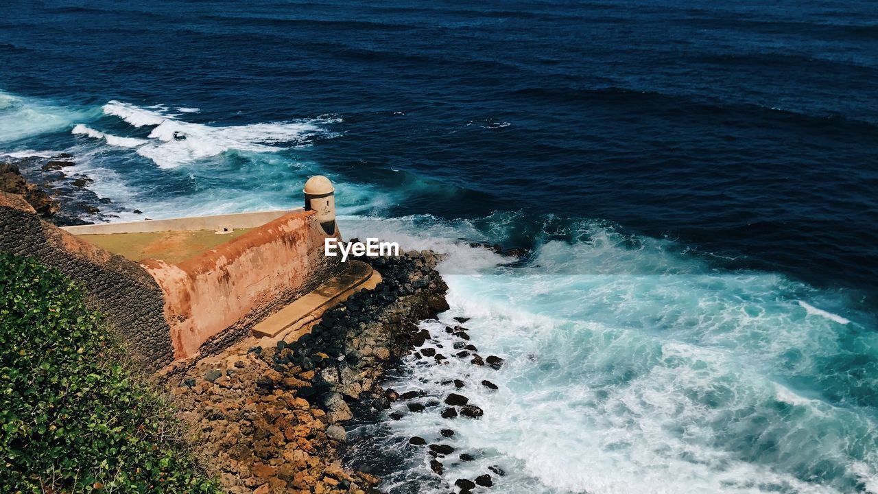 High angle view of wave splashing on fortified wall