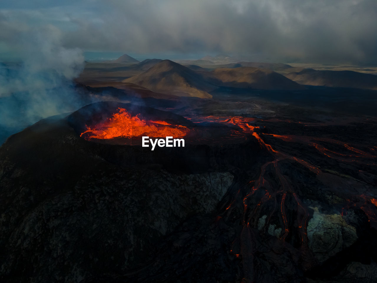 Scenic view of erupting lava on mountain during sunset