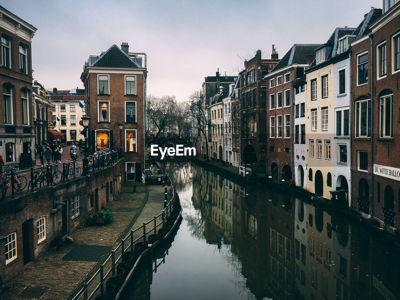 Canal amidst buildings against sky