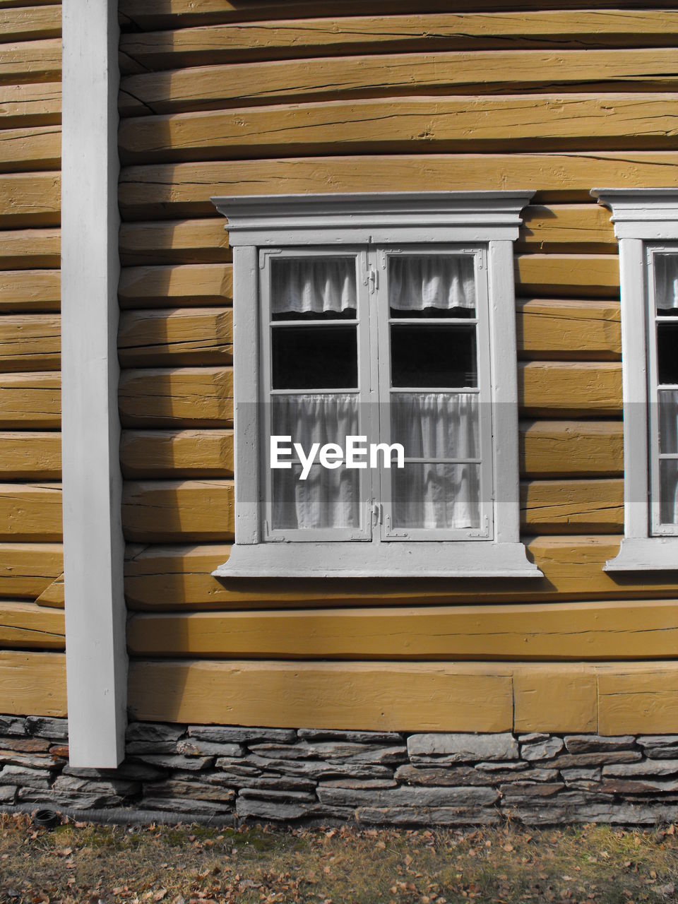 CLOSE-UP OF YELLOW WINDOW OF BUILDING