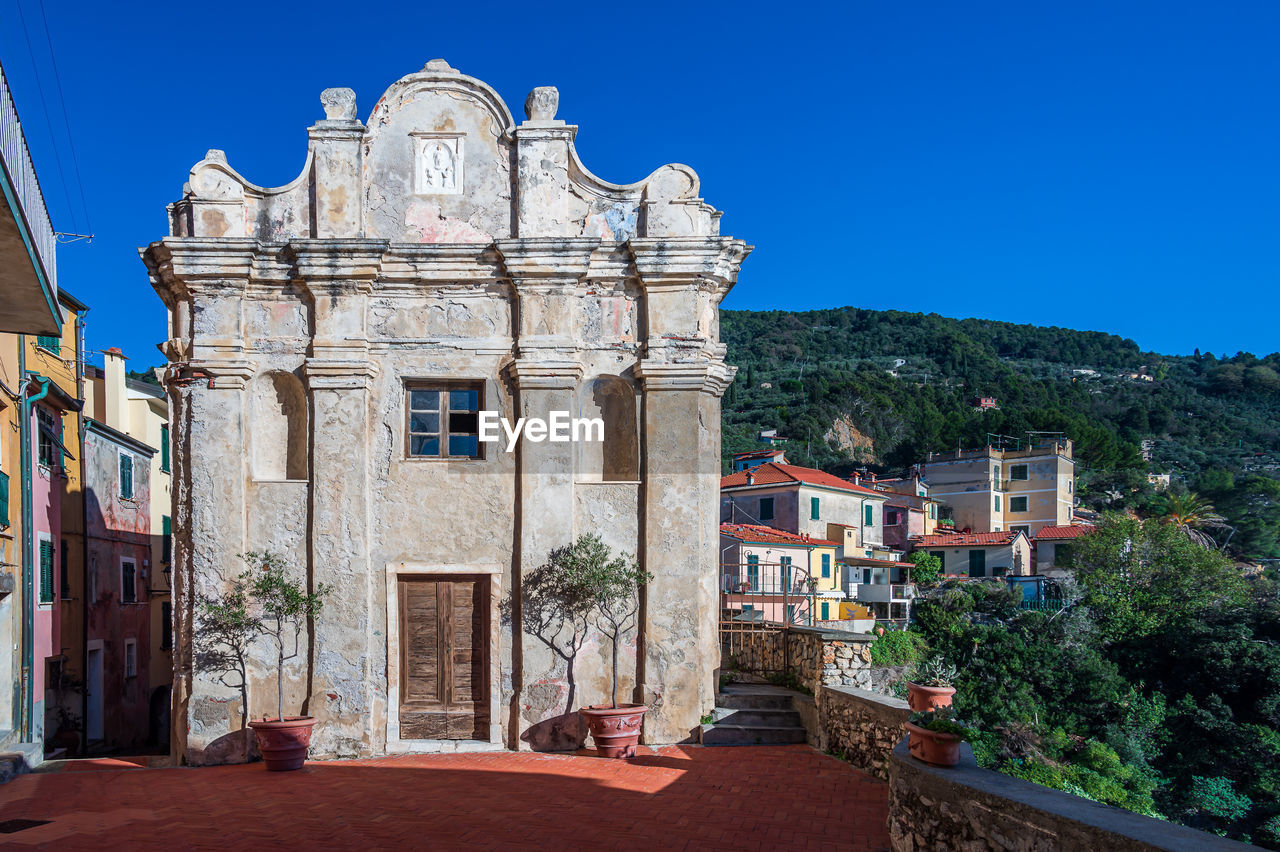 architecture, building exterior, built structure, town, building, travel destinations, city, sky, clear sky, nature, blue, travel, history, the past, landmark, religion, tourism, sunny, no people, residential district, place of worship, house, old, vacation, street, outdoors, estate, belief, tree, plant, day, tower, medieval, landscape, spirituality, sunlight
