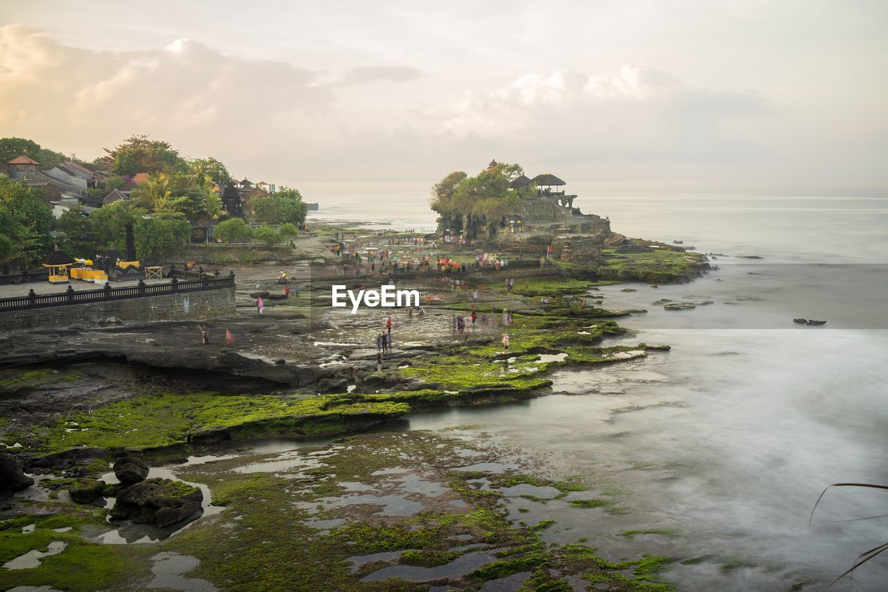 Scenic view of sea by buildings against sky