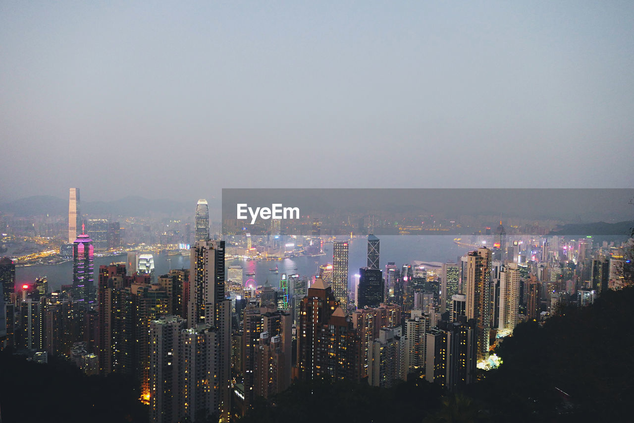 Aerial view of illuminated buildings in city against sky