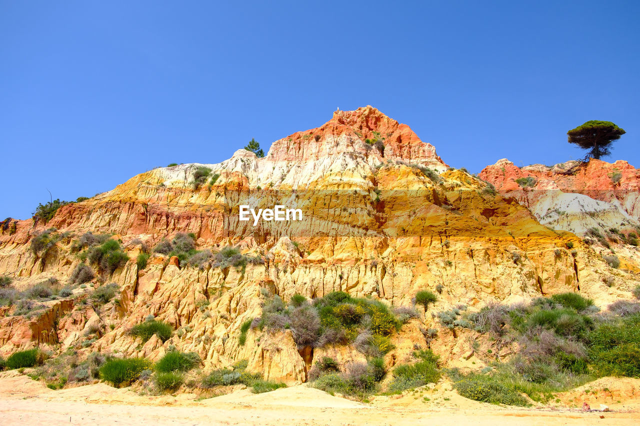 Scenic view of mountain against blue sky