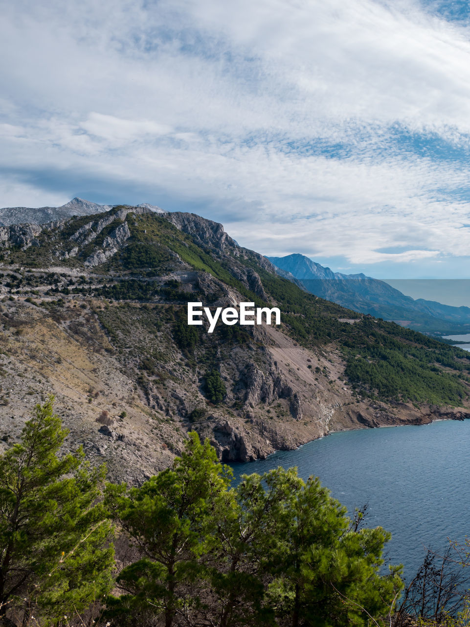 Scenic view of mountain by sea against sky